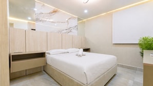 A modern bedroom with a large bed, a bedside table, a mirror, and a small plant. - ¡Céntrico & Nuevo! Gym, Parking & Pool - 2BR2br 6G (Monterrey)