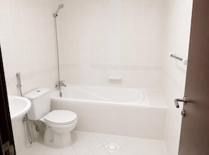 A bathroom with a toilet, sink, and bathtub.