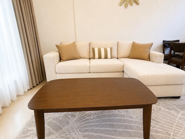 A living room with a sofa, a coffee table, and a chair.