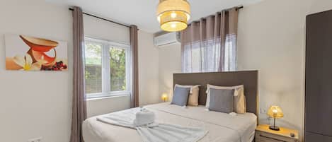 Ein Hotelzimmer mit Bett, Nachttischlampe und einem Gemälde an der Wand.