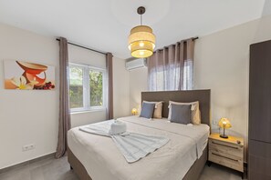 Una habitación de hotel con cama, lámpara de noche y un cuadro en la pared.
