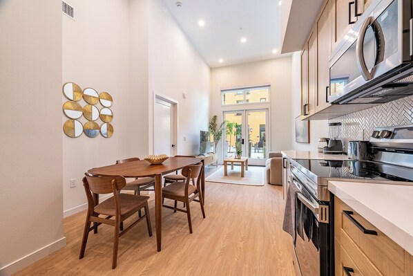 A modern kitchen with a built-in oven, a microwave, and a stainless steel range hood.