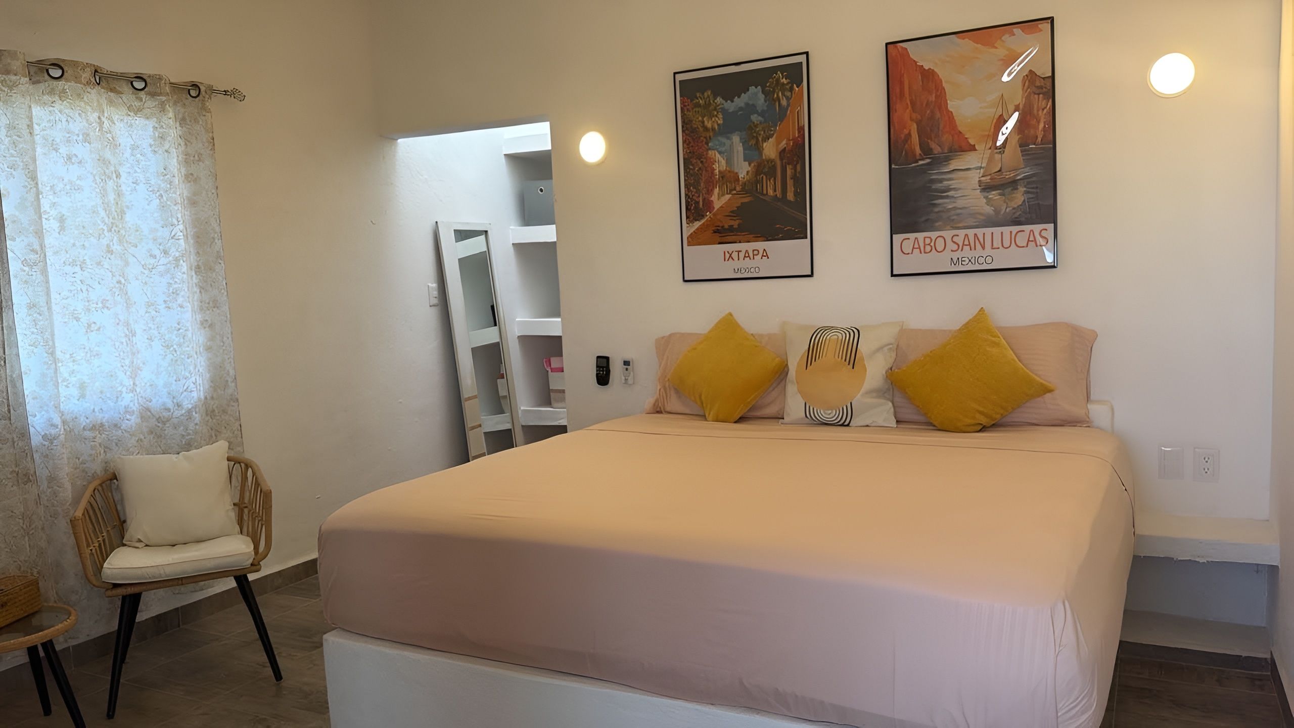 Una camera da letto con un letto, una sedia, un armadio e due quadri appesi al muro.