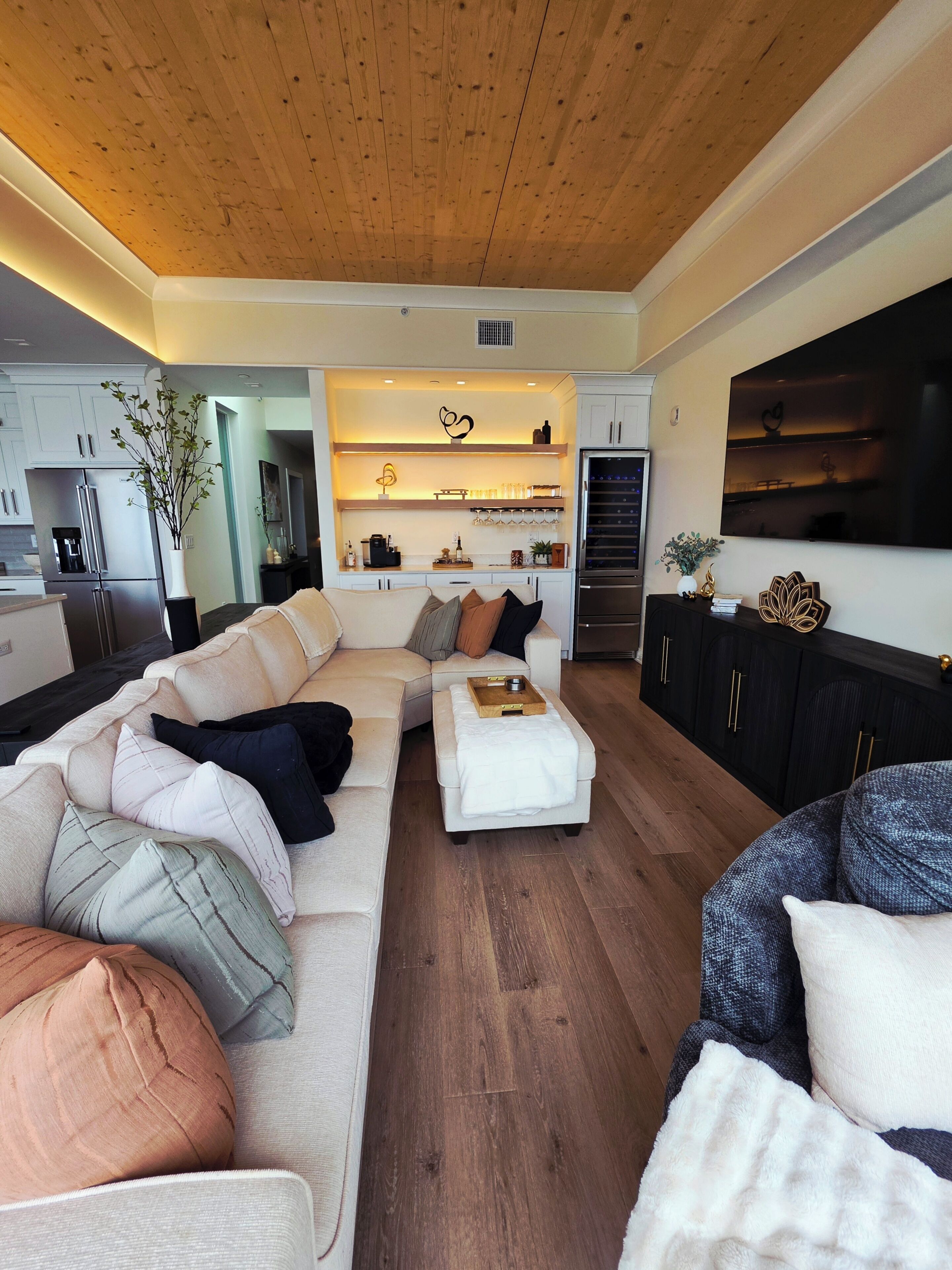 Een moderne woonkamer met een hoekbank, een salontafel en een televisie.