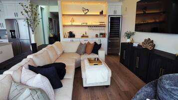 Een moderne woonkamer met een hoekbank, een salontafel en een televisie.