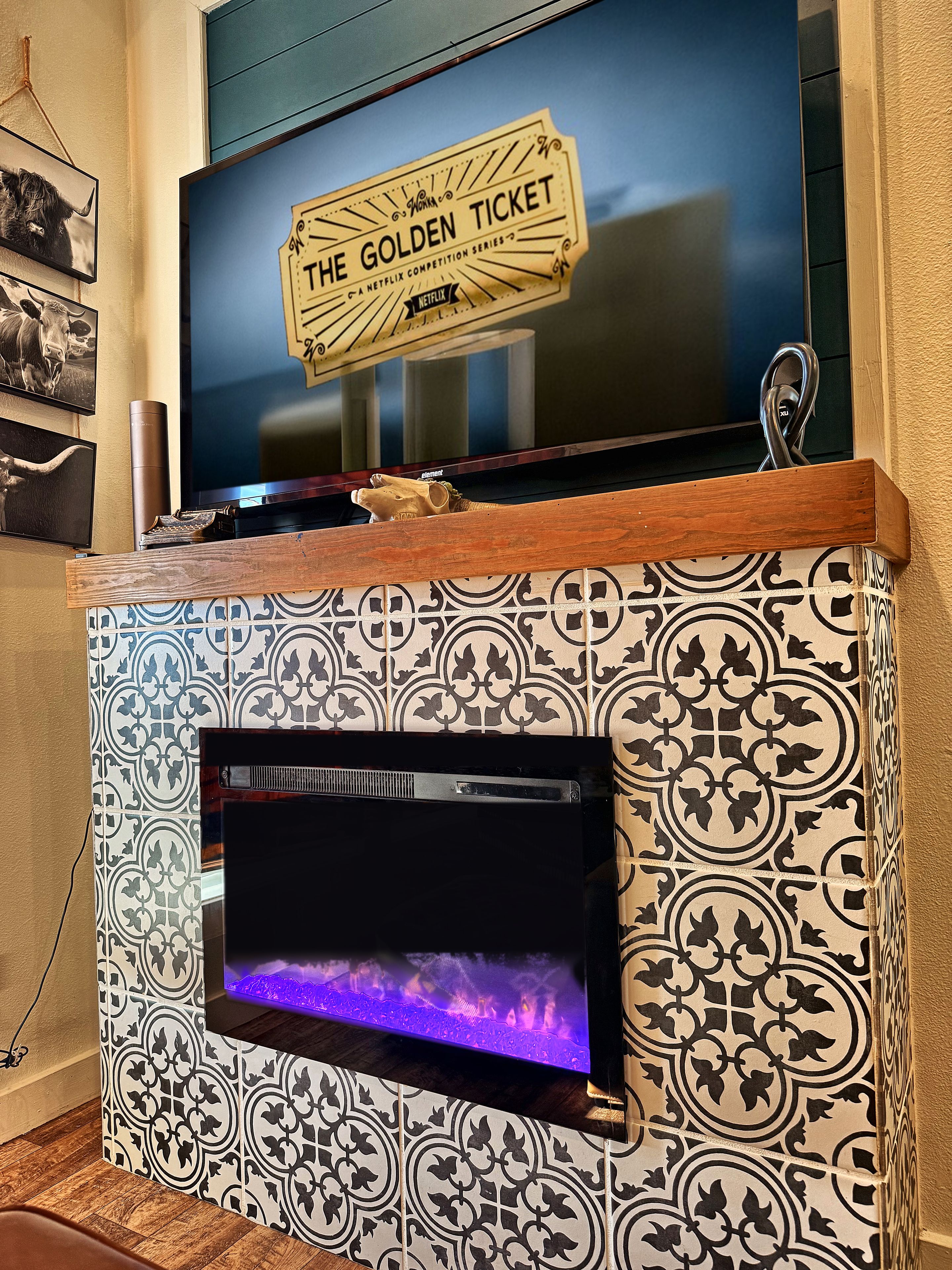 Un téléviseur fixé au mur, avec un panneau décoratif placé au-dessus.