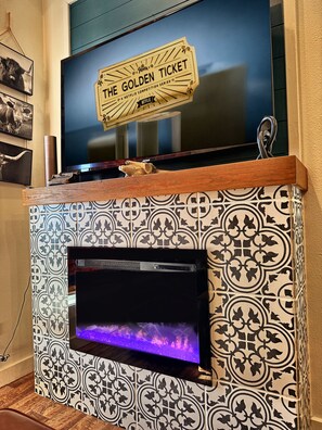 A television mounted on a wall with a decorative sign above it. - Tiny Home overlooking 1,800 Acres! Waxahachie Tx 30 to Dallas (Waxahachie)