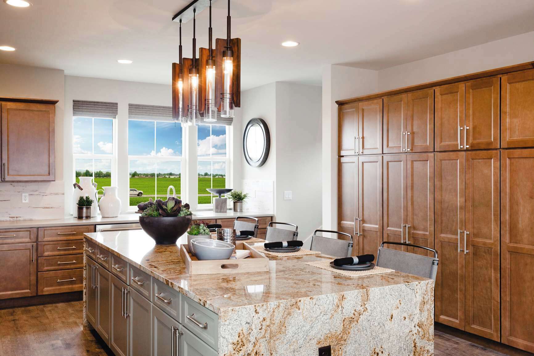 Una cocina moderna con encimeras de granito, armarios de madera y una isla grande.