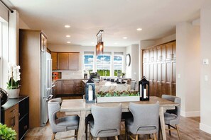 A modern kitchen with a central island, wooden cabinets, and a view of the outdoors.
