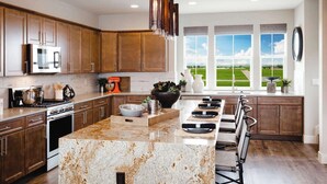 A modern kitchen with granite countertops, stainless steel appliances, and a large island. - Iconic Big Sky Getaway | Epic Yellowstone Retreat! (Belgrade)
