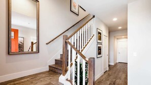 Un escalier avec des marches en bois et une rampe blanche, menant à une porte.