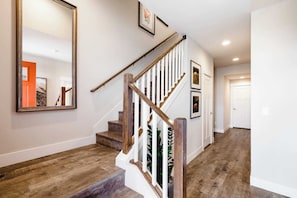 A staircase with wooden steps and white railings, leading to a door.