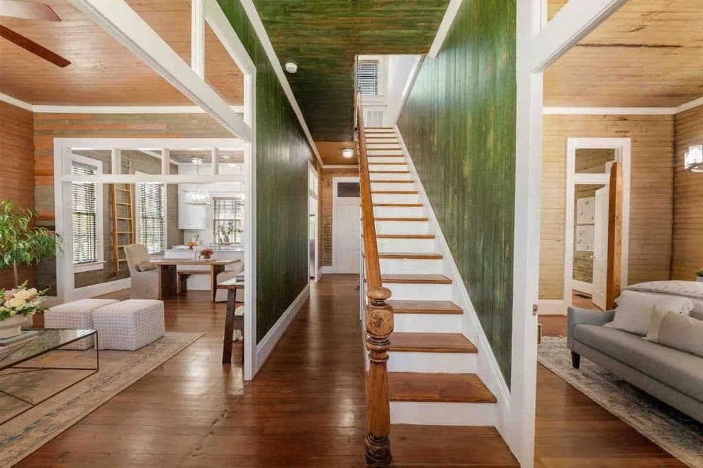 A spacious interior with a wooden staircase, a dining area, and a living room.