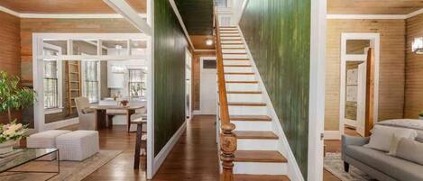 A spacious interior with a wooden staircase, a dining area, and a living room.