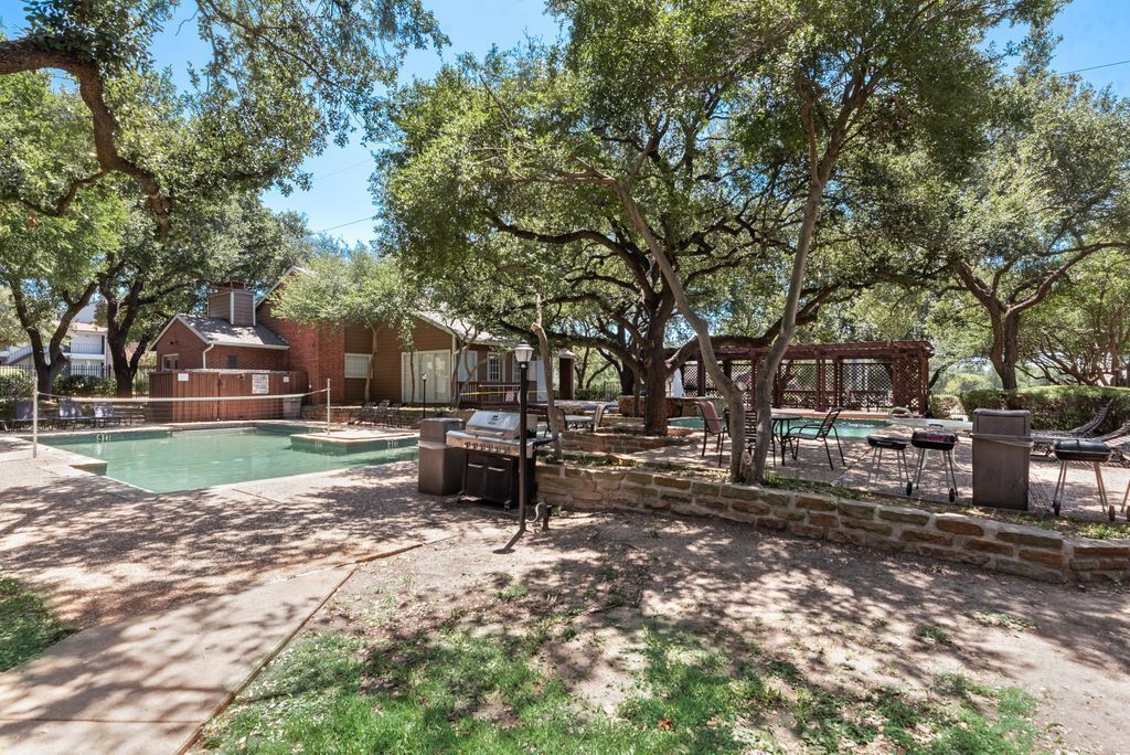 A backyard with a swimming pool, barbecue area, and outdoor seating.