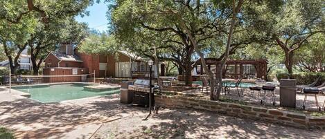 A backyard with a swimming pool, barbecue area, and outdoor seating.