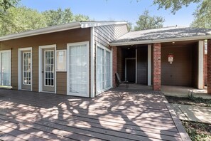 Een gebouw met twee verdiepingen, een overdekte veranda en een garage.