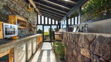 Una cocina moderna con paredes de piedra, armarios de madera y un amplio ventanal.