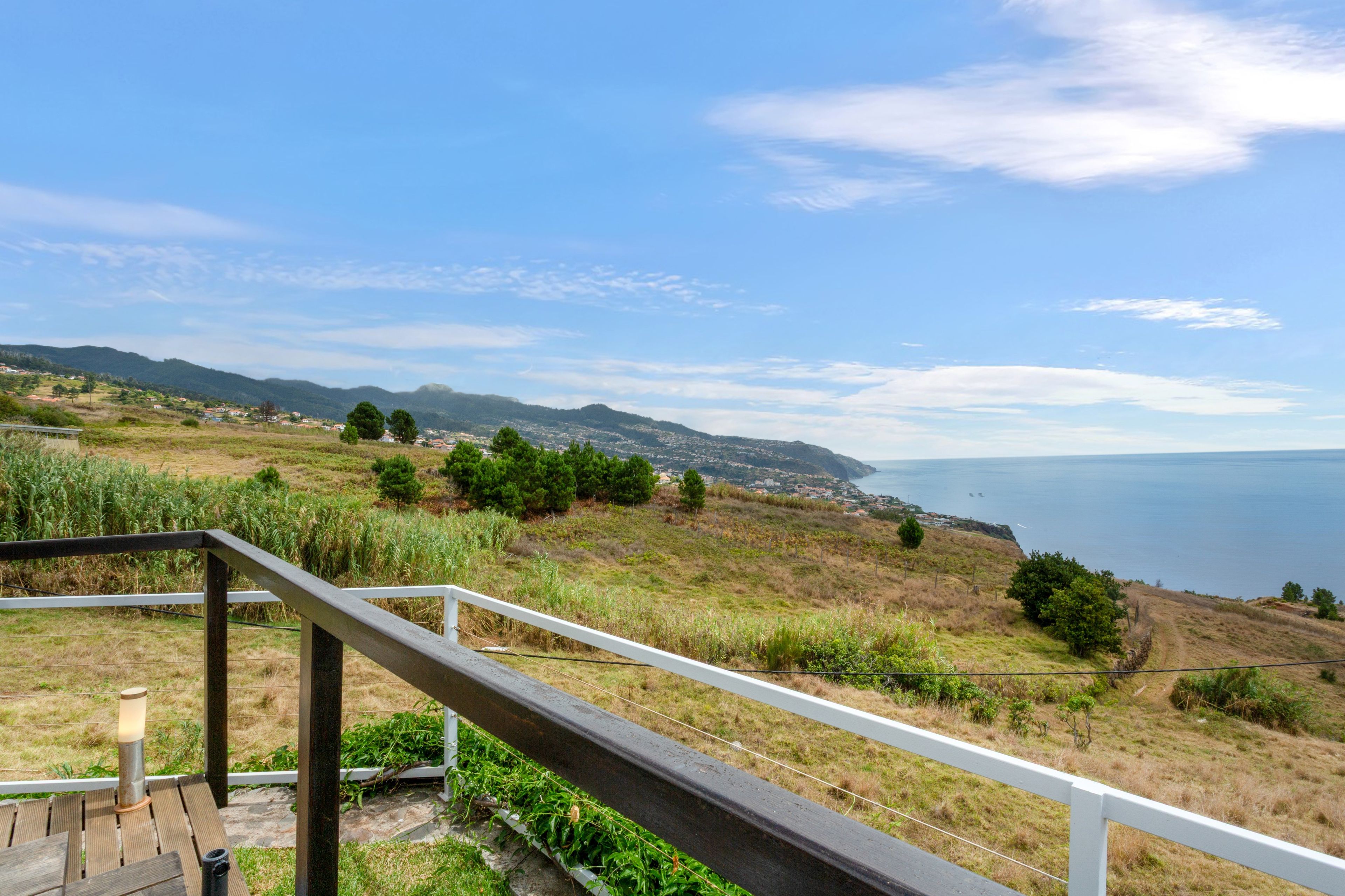 Eine Küstenlandschaft mit Blick auf das Meer und ferne Hügel.