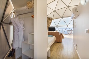 Una habitación con cama, televisión y vista al mar.
