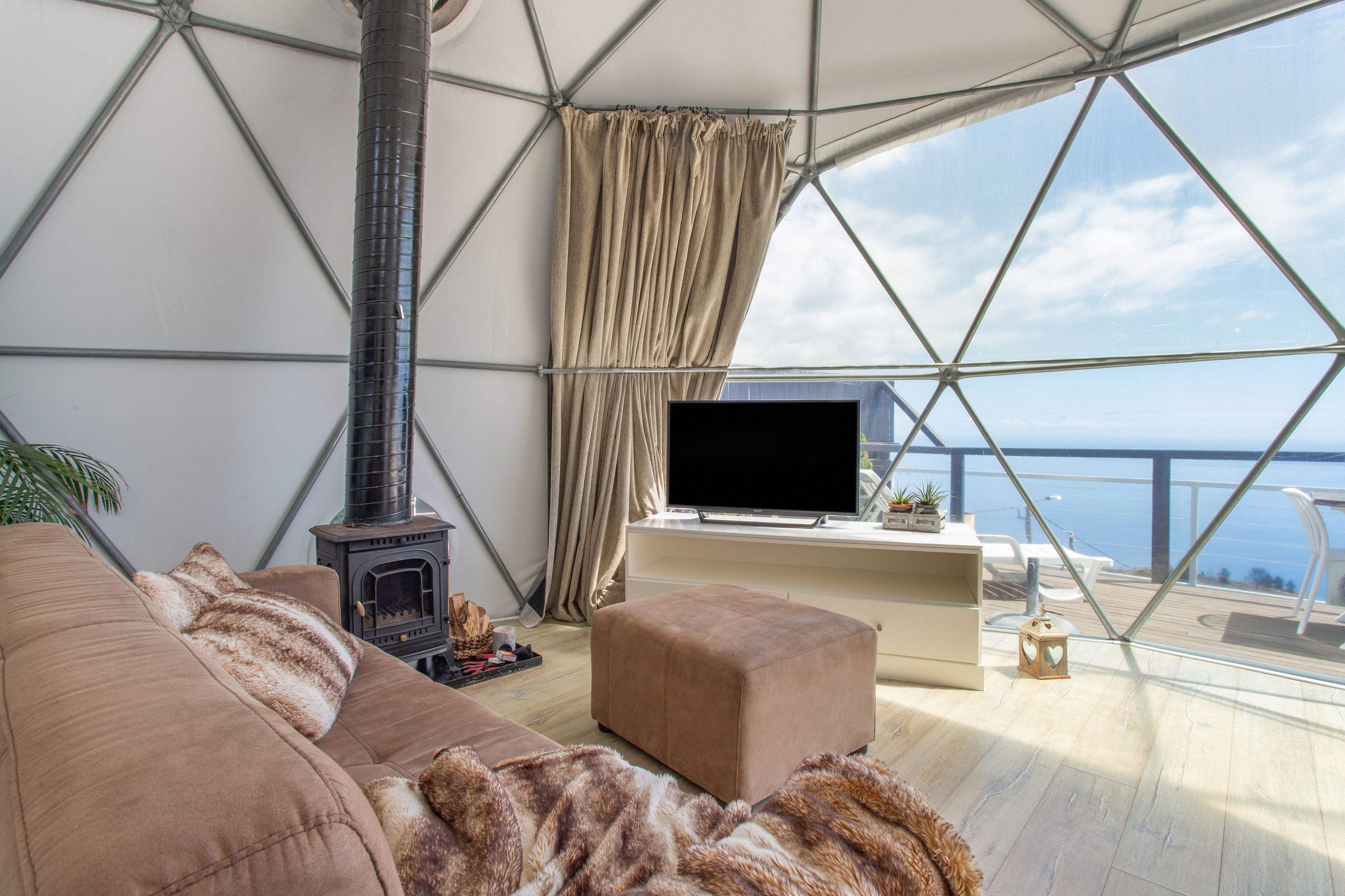 Una habitación acogedora con sofá, reposapiés y chimenea.