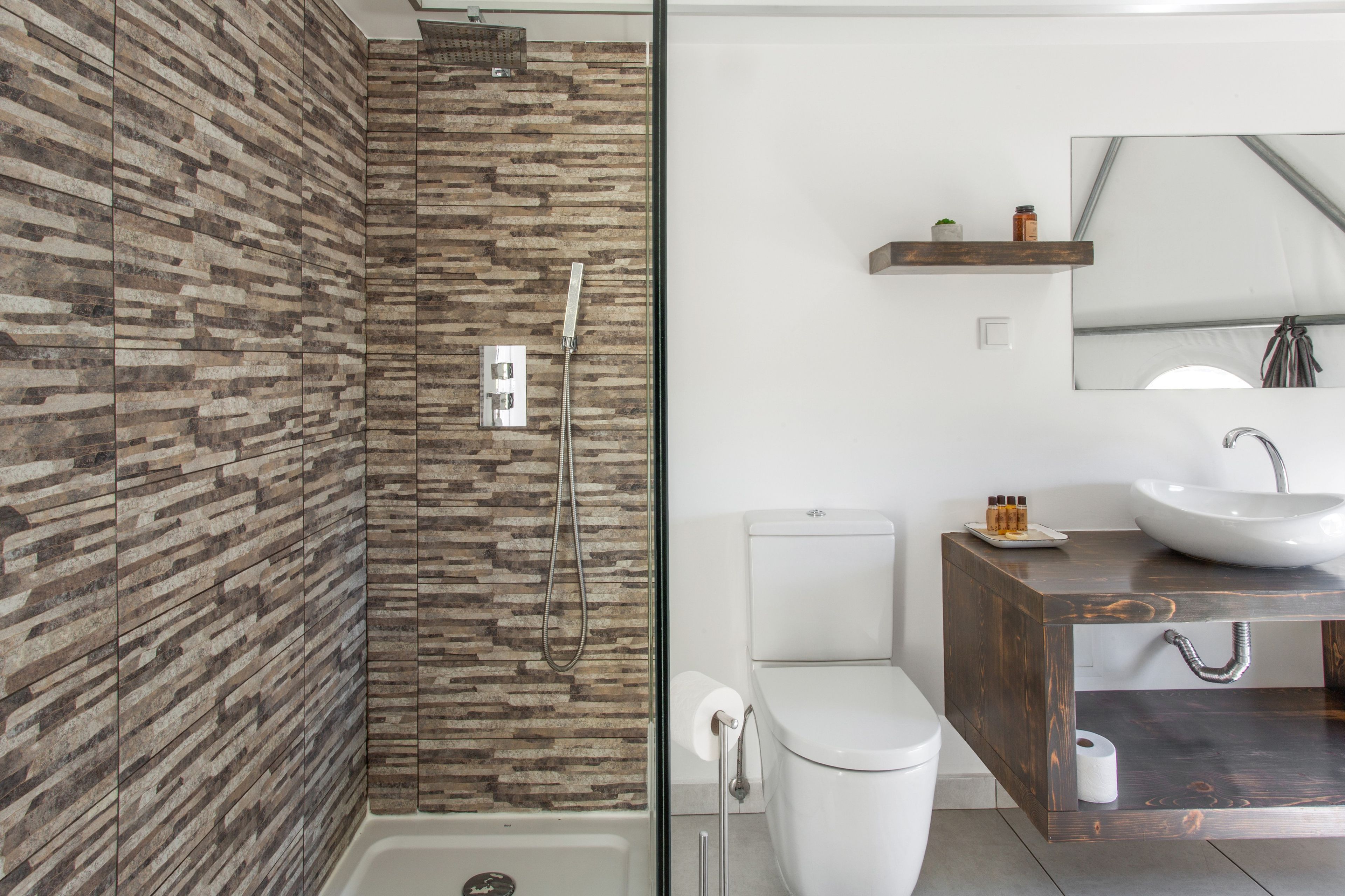Un baño moderno con ducha, inodoro y tocador.