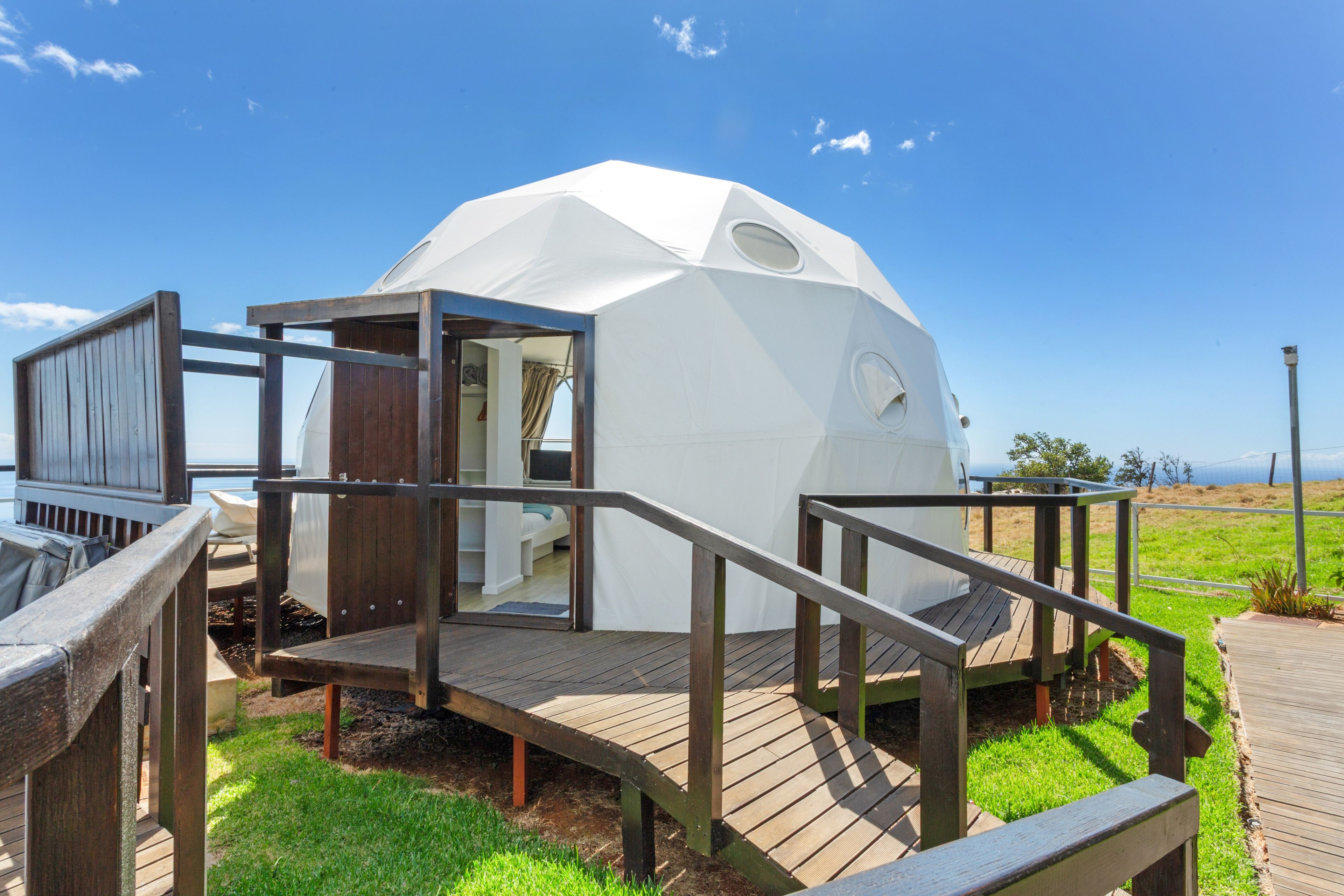 Una estructura de cúpula geodésica con un piso de madera y un pequeño espacio cerrado.