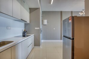 Una cocina moderna con armarios blancos, un refrigerador de acero inoxidable y un horno empotrado.