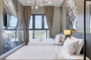 Habitación de hotel con una cama grande, un televisor montado en la pared y vistas a la ciudad desde la ventana.
