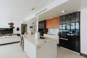 Una cocina moderna con una isla central, un área de comedor con sofá y un amplio ventanal con vistas.