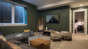 A living room with a sofa, a ladder, a painting, and a bookshelf. - Yampa Valley Views, Hot Tub + Wildhorse Gondola Access | Konik Chalet (Steamboat Springs)
