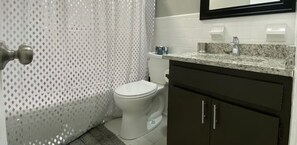 Un baño con inodoro, lavamanos y un armario.