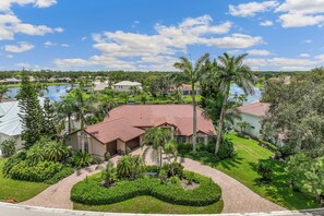 A residential area with houses, a swimming pool, and lush greenery. - Naples winter get away...Everything you could want: Pool, 3bedroom, 2.5 bathroom (Naples)