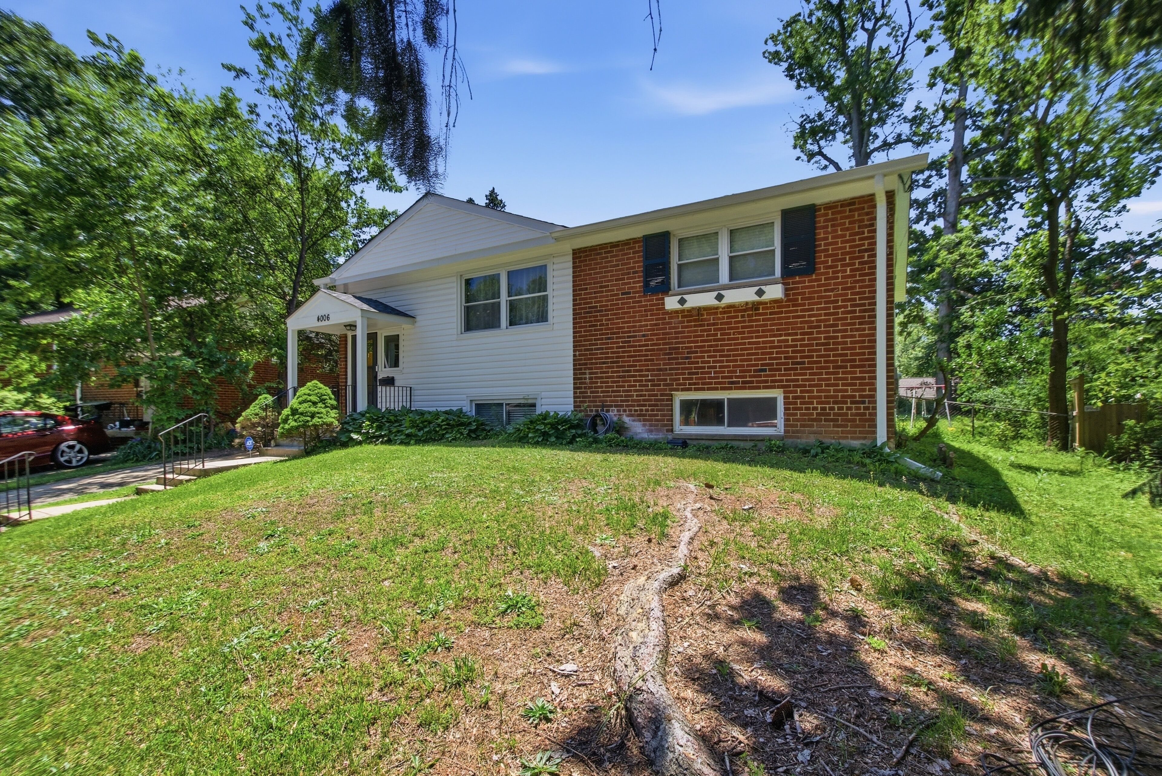 A two-story house with a brick exterior and a white front porch.