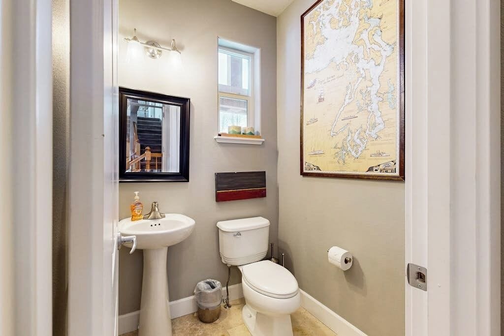 A bathroom with a sink, toilet, and a map on the wall.