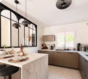 A modern kitchen with a marble island, pendant lights, and a large window. - Bright, air-conditioned house in Aix-en-Provence (Aix-en-Provence)