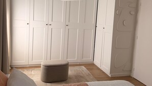 A bedroom with a bed, a hanging light fixture, a wardrobe, and a small ottoman. - Bright, air-conditioned house in Aix-en-Provence (Aix-en-Provence)