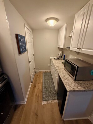 A compact kitchen with white cabinets, a microwave, and a small sink. - Lakefront Retreat w/Private Dock-Close to Virginia Tech and Radford University (Dublin)