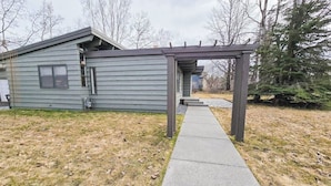A residential property with a covered patio, a concrete pathway, and a detached garage.