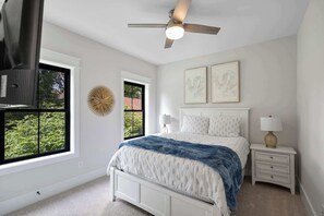 A bedroom with a bed, bedside tables, a ceiling fan, and artwork on the wall. - Rooftop Retreat: Steps to Downtown Square (Murfreesboro)