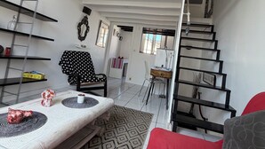 Ein Loft-Zimmer mit Bett, Essbereich und Treppe.