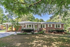 A single-story brick house with a front porch, a covered patio, and a well-maintained lawn. - Starling House/Huge Fenced Yard/Pet-Friendly (Mableton)