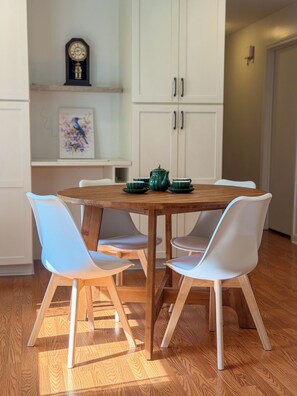 A dining area with a wooden table, white chairs, and a green teapot. - Starling House/Huge Fenced Yard/Pet-Friendly (Mableton)