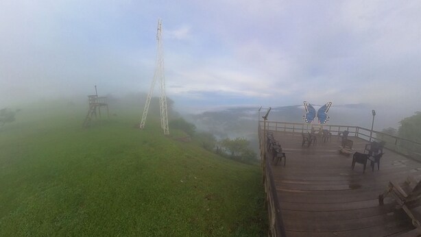 A foggy outdoor area with a wooden platform, chairs, and a metal structure. - Eramon Paradise 360 (Nombre de Jesús)