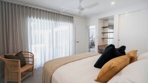 Ein Hotelzimmer mit Bett, Stuhl, Kleiderschrank und Deckenventilator.
