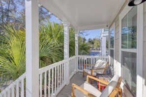 A covered porch with white railings and wooden chairs. - Free Golf Cart | 1 Mi to Downtown & Beach (Ocean Springs)