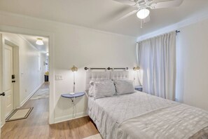 A bedroom with a bed, bedside table, and a ceiling fan. - Free Golf Cart | 1 Mi to Downtown & Beach (Ocean Springs)