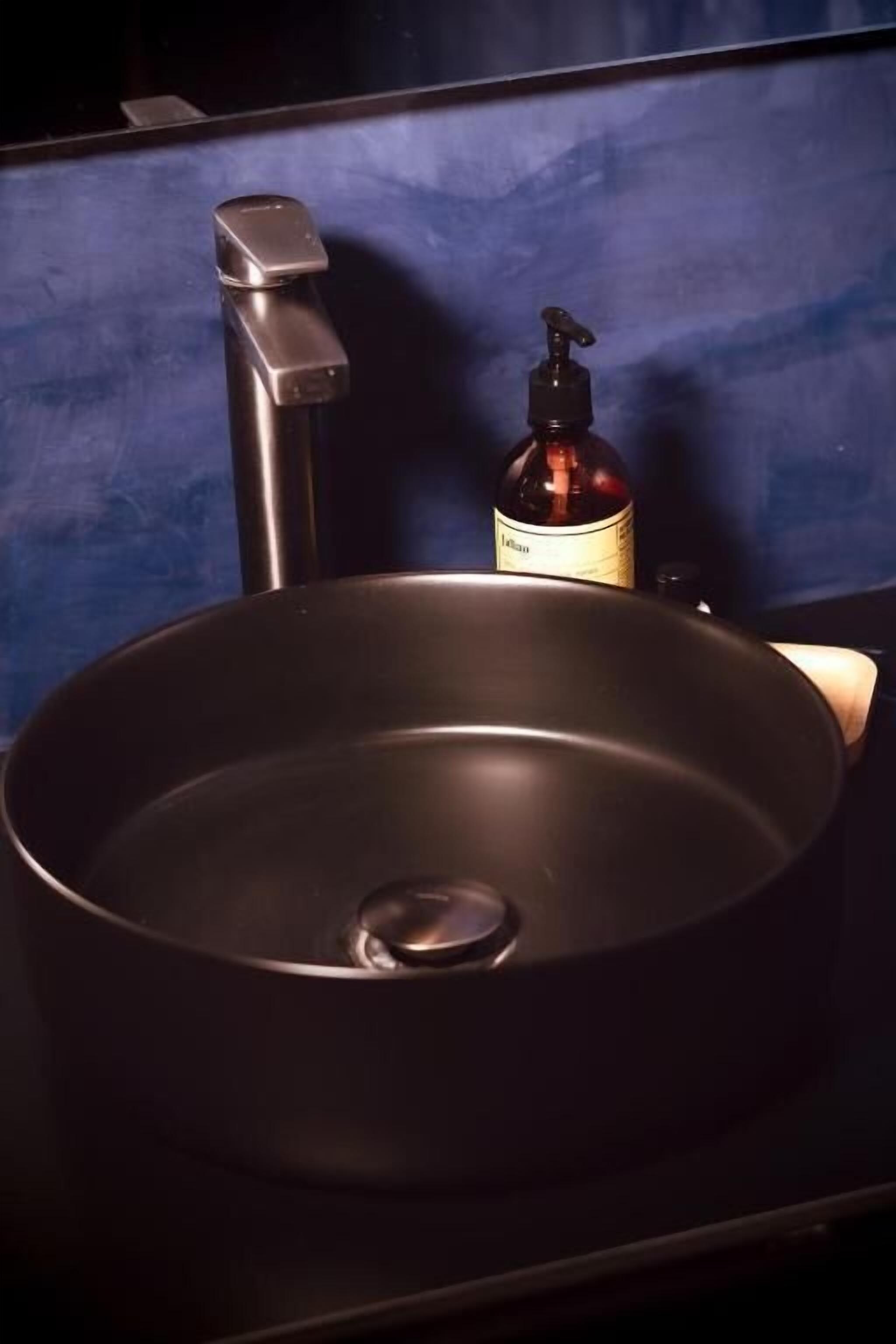 A kitchen sink with a faucet and a soap dispenser.