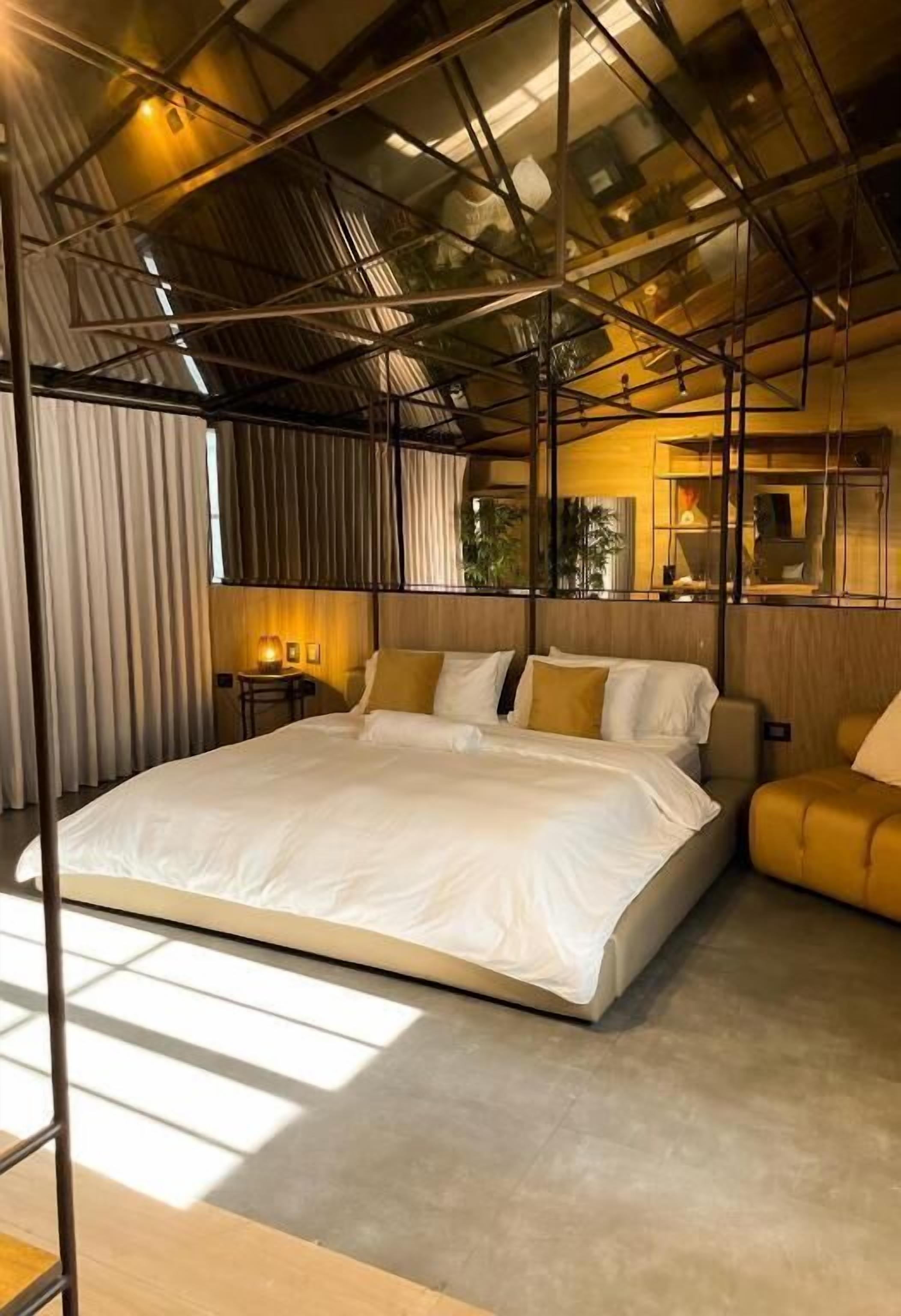 Un dormitorio moderno con una cama grande, una mesita de noche y una silla.