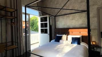 Un dormitorio moderno con cama con dosel, estante empotrado y vistas al exterior.